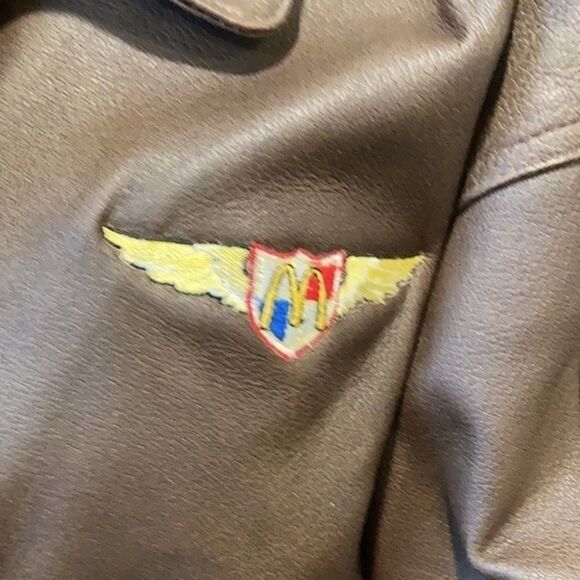 Burks Bay  leather brown coat has a patch on the left side. - Picture 3 of 8